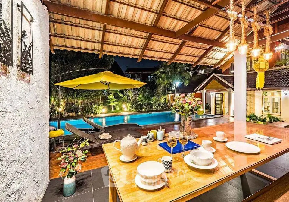 Luxurious outdoor dining area with pool view and elegant decor, perfect for entertaining guests.