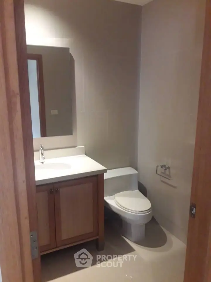 Modern bathroom with sleek fixtures and wooden cabinetry in a contemporary home.
