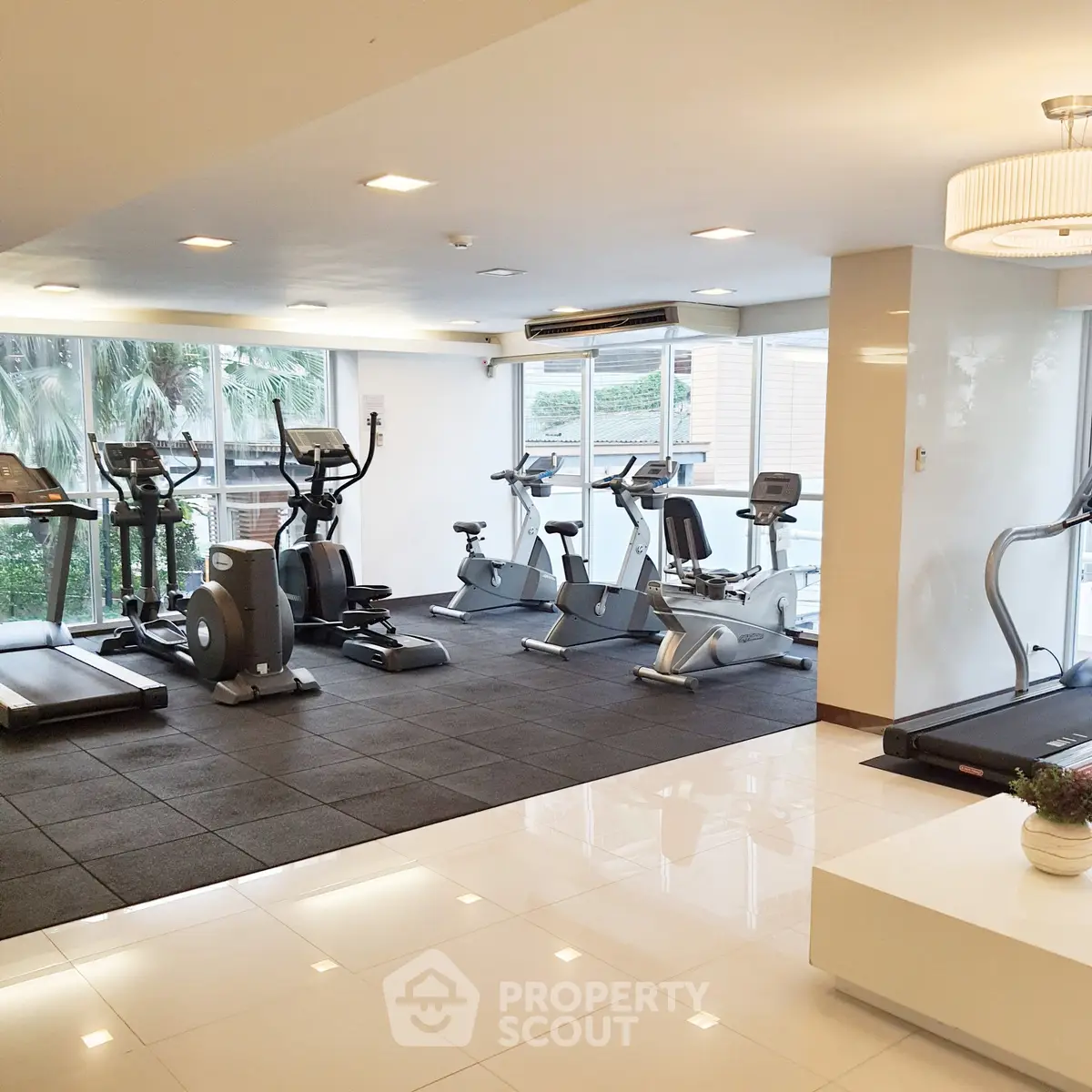 Modern gym with state-of-the-art equipment and large windows offering a refreshing view.