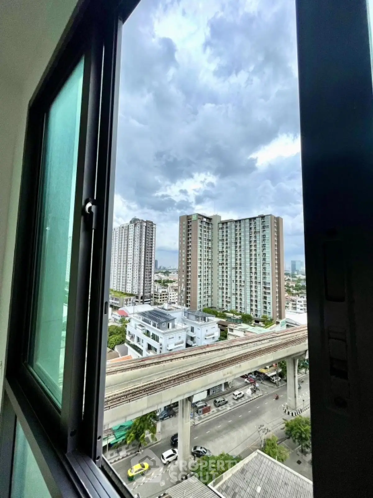 Stunning cityscape view from high-rise apartment window showcasing urban living.