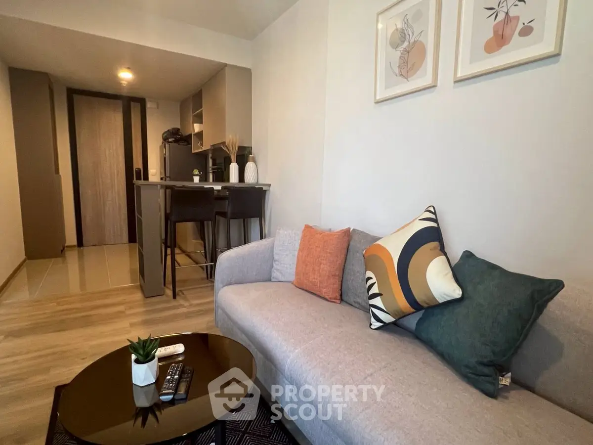 Modern living room with stylish decor and open kitchen layout, perfect for cozy urban living.