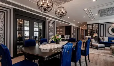 Luxurious dining room with elegant decor and plush blue chairs in a modern apartment.