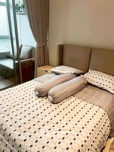 Cozy bedroom with modern decor and large window for natural light.