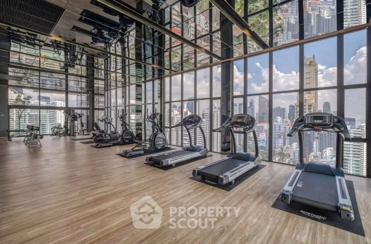 Luxurious high-rise gym with panoramic city views and modern equipment.