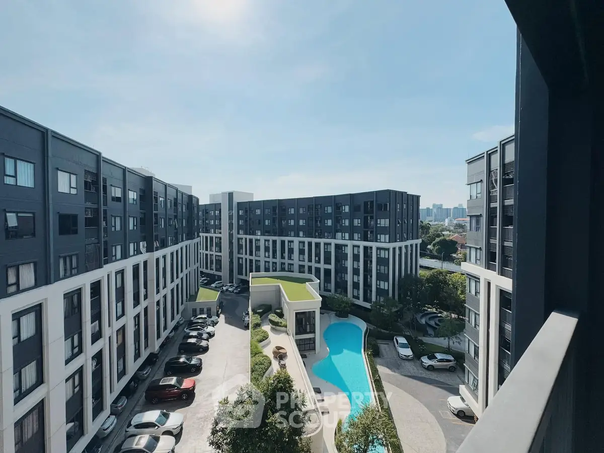 Modern apartment complex with pool and parking, offering urban living with scenic views.