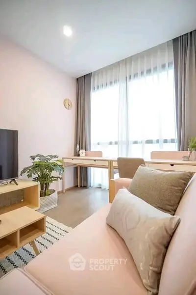 Charming living room with pastel decor and large window, perfect for relaxation and entertainment.