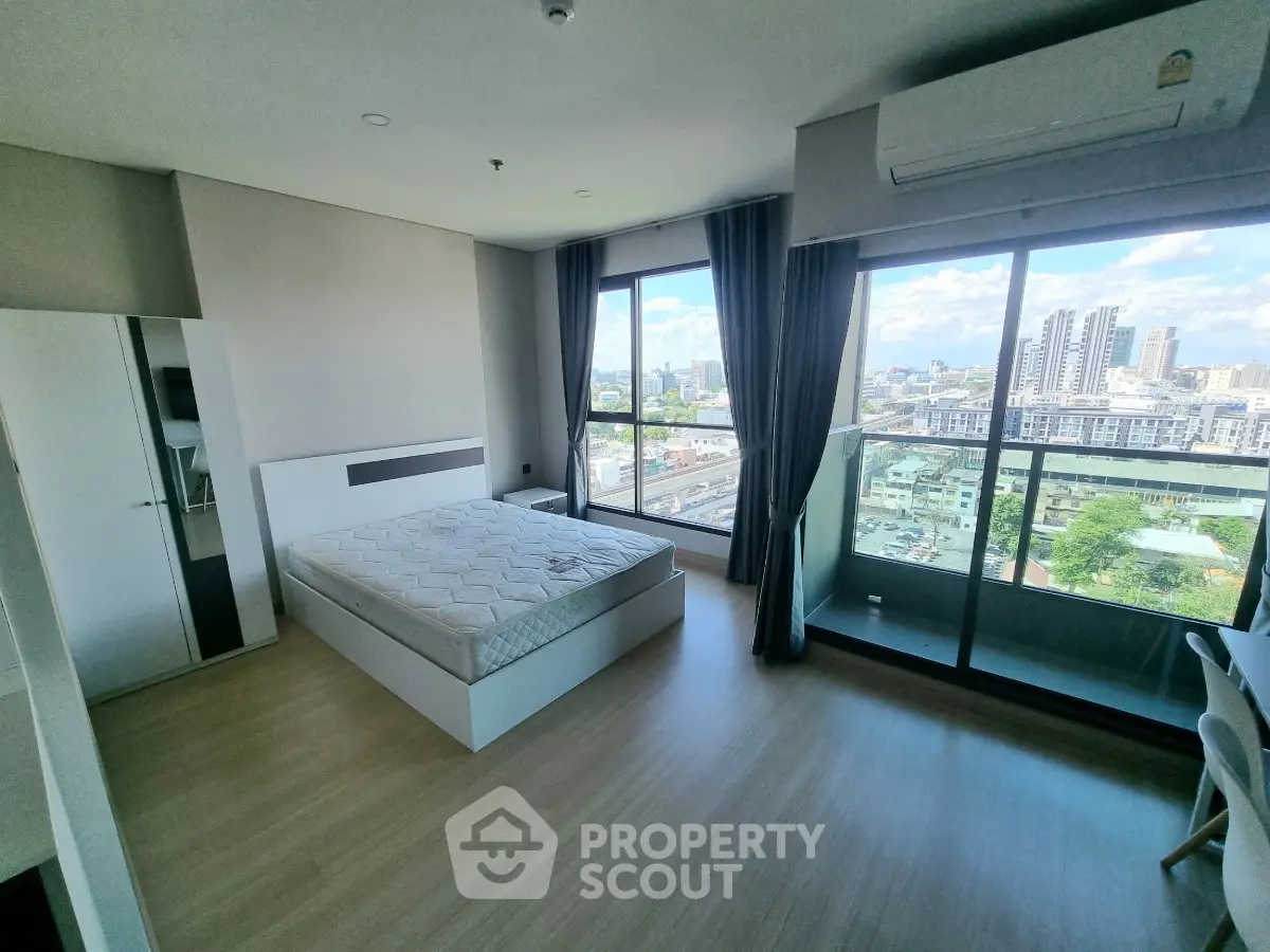 Spacious bedroom with city view and balcony access in modern apartment