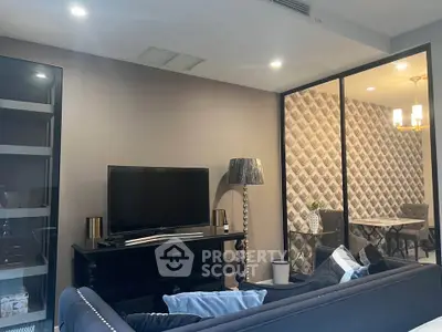 Modern living room with stylish decor and adjacent dining area, featuring elegant lighting and contemporary furniture.