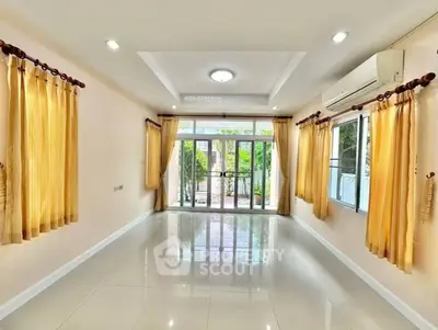 Spacious living room with large windows and elegant curtains