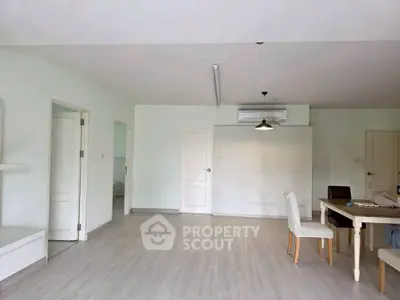 Spacious open-plan living area with modern dining setup and air conditioning.