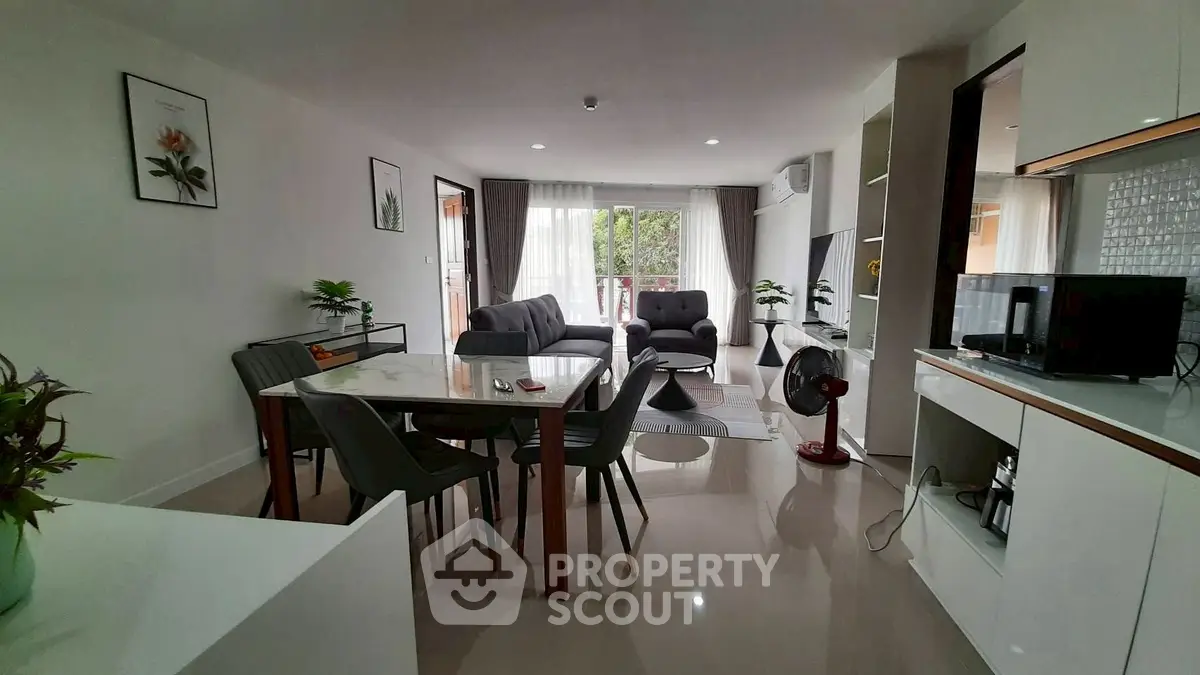Spacious modern living room with dining area and balcony access