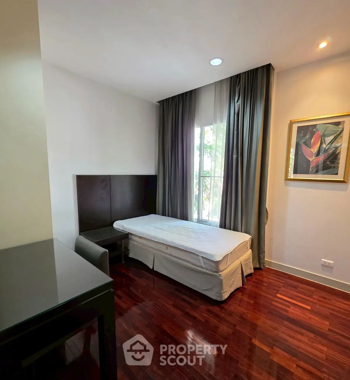 Cozy bedroom with hardwood floors and natural light in modern apartment