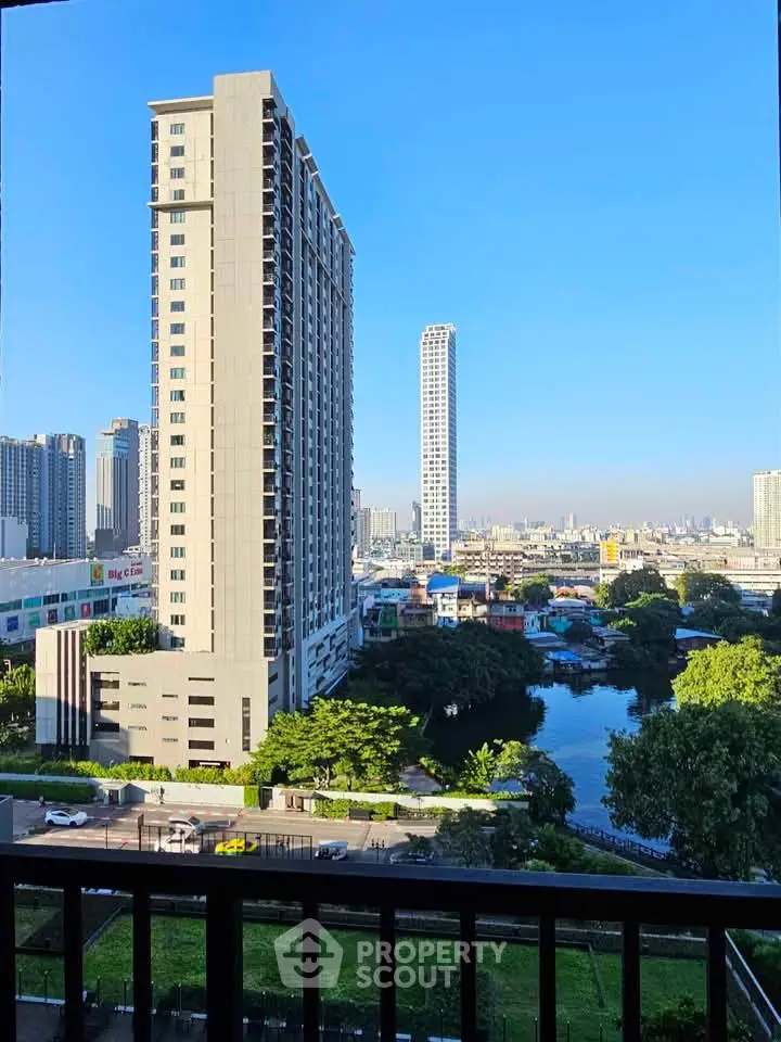 Stunning cityscape view from a high-rise balcony overlooking a serene river and urban skyline.