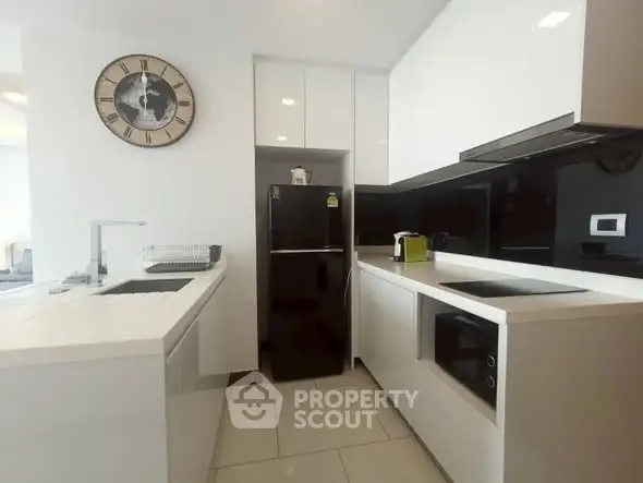 Modern kitchen with sleek white cabinetry and black appliances