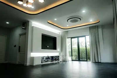 Modern living room with sleek design, large windows, and stylish ceiling lighting.