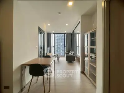 Modern living room with large windows and stylish furniture in a high-rise apartment.