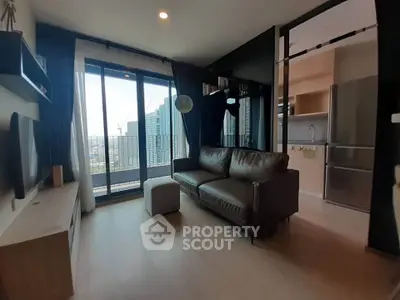 Modern living room with city view, sleek furniture, and open kitchen layout.