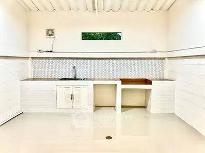 Modern minimalist kitchen with sleek white cabinetry and geometric backsplash