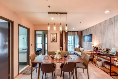 Modern dining area with stylish lighting and cozy living room view