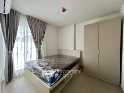 Modern bedroom with large window and stylish wardrobe in a cozy apartment.