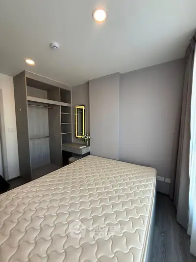 Modern bedroom with built-in wardrobe and large window offering natural light.