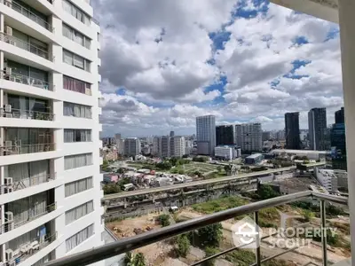 Stunning cityscape view from modern high-rise balcony with clear skies.