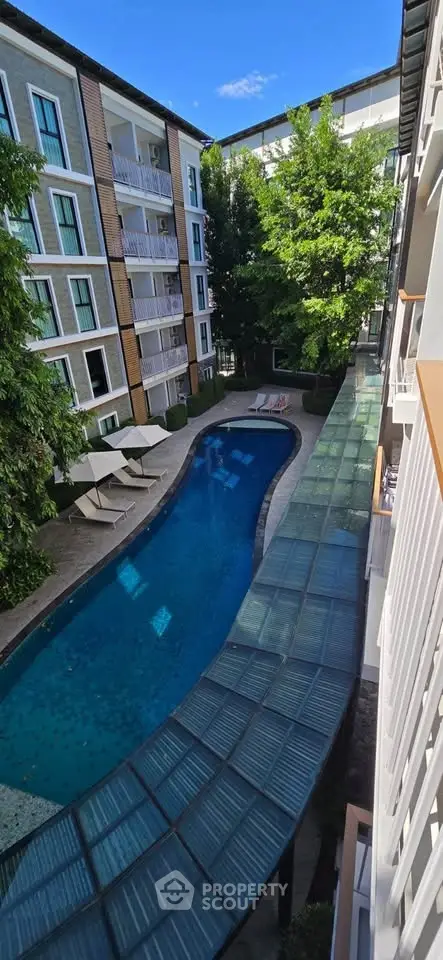 Stunning apartment complex with a beautiful outdoor pool and lush greenery, perfect for relaxation and leisure.
