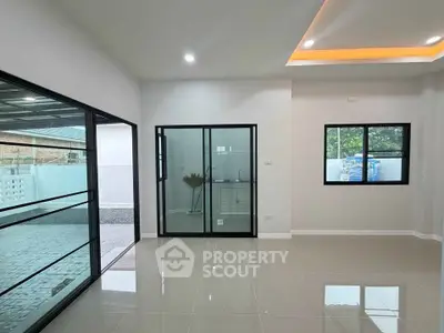 Modern interior with sleek glass doors and large windows in a spacious living area.