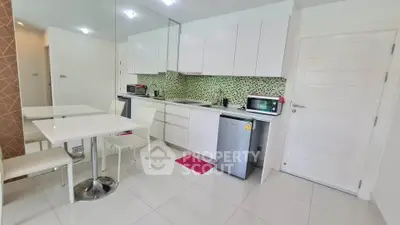 Modern kitchen with sleek white cabinets and dining area in stylish apartment