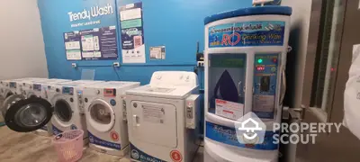 Modern laundry room with washing machines and water dispenser in vibrant blue setting.