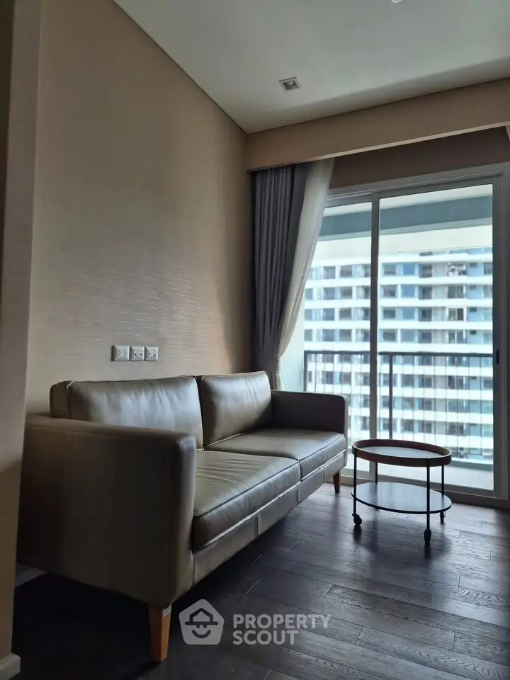 Modern living room with sleek sofa and balcony view in high-rise apartment