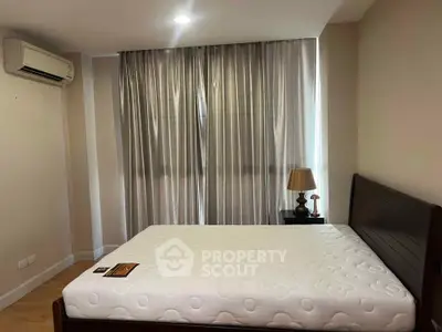 Cozy bedroom with large window and elegant curtains, featuring a comfortable bed and stylish lamp.