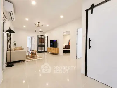Modern living room with sleek design and open layout, featuring stylish furniture and bright lighting.