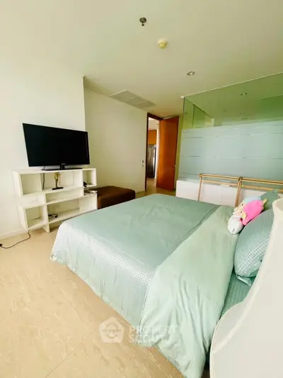 Modern bedroom with stylish decor and TV, featuring a comfortable bed and elegant furnishings.