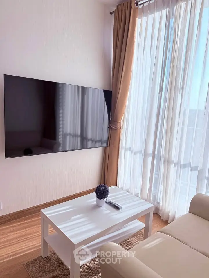 Bright living room with large TV and elegant curtains