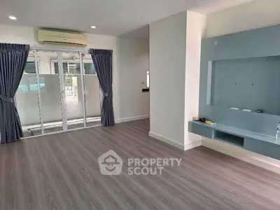 Spacious living room with modern flooring and large windows for natural light.