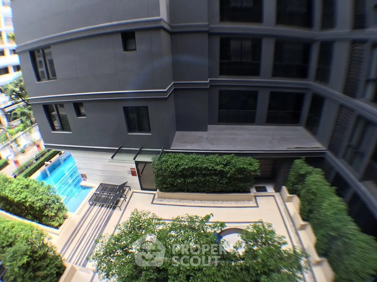 Modern apartment building exterior with lush greenery and pool view