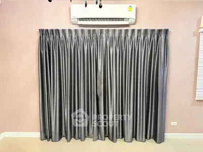 Modern interior with elegant gray curtains and air conditioning unit, perfect for comfortable living.
