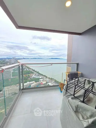 Stunning high-rise balcony with panoramic ocean view and modern glass railing.