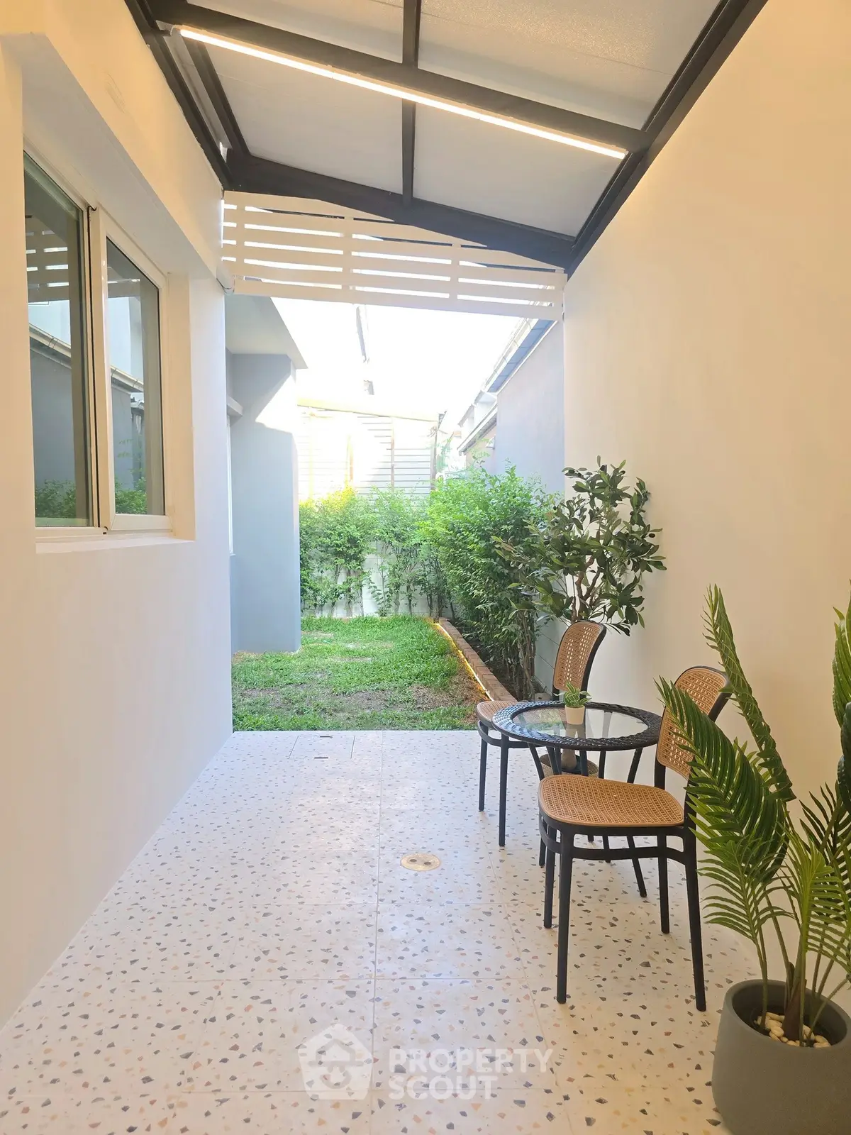 Charming outdoor patio with modern seating and lush greenery, perfect for relaxation and entertaining.