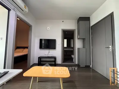 Modern apartment living room with sleek design and adjacent bedroom view.