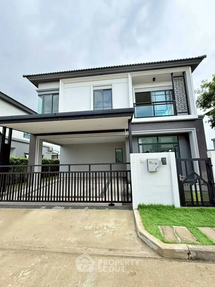 Modern two-story house with sleek design and spacious driveway in a serene neighborhood.
