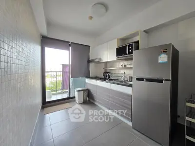Modern kitchen with sleek cabinets, large fridge, and balcony view.