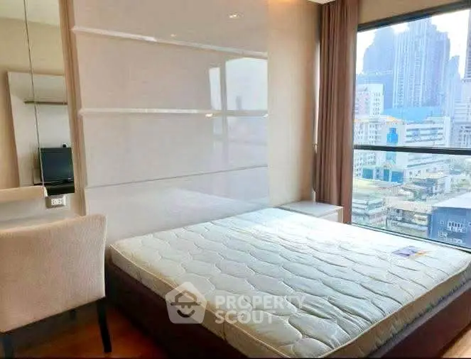 Modern bedroom with city view, featuring a comfortable bed and sleek design.