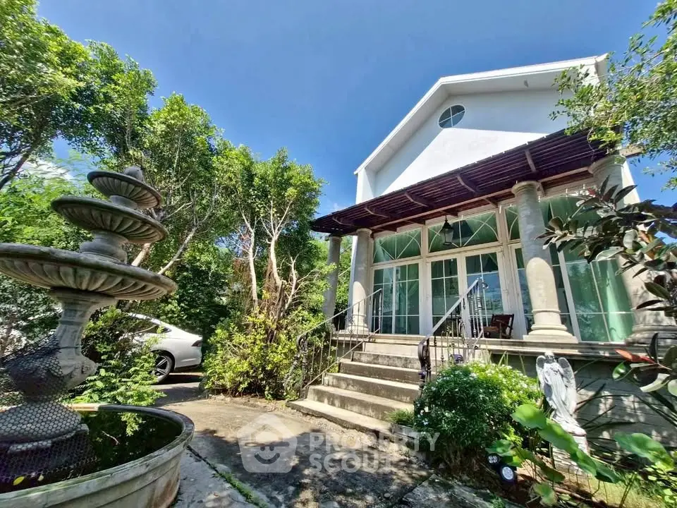 Charming two-story house with lush garden and elegant entrance