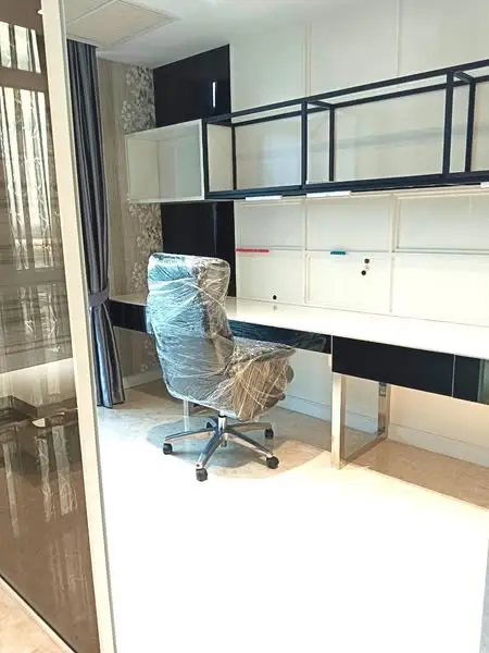 Modern study room with sleek desk and office chair, natural light through large window.