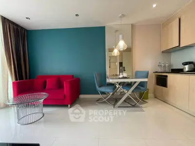 Modern living room with vibrant red sofa and sleek dining area in open layout.