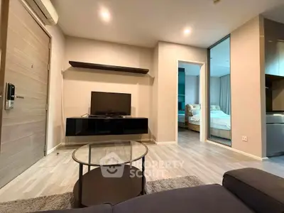 Modern living room with sleek furniture and open view into a cozy bedroom