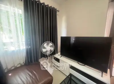 Cozy living room with modern TV setup and natural light
