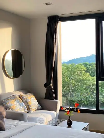 Cozy bedroom with scenic view, featuring a stylish sofa and elegant decor.